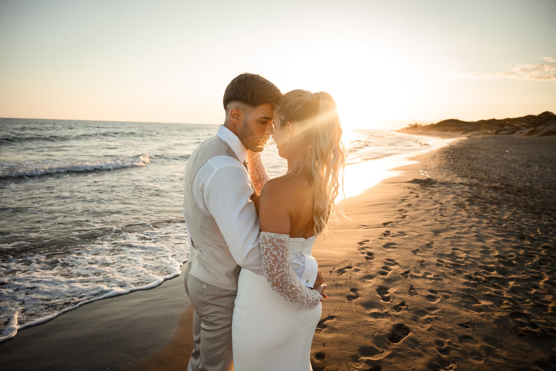 Pareja abrazada en la playa al atardecer